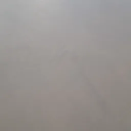 Jasnoszara, gładka powierzchnia z subtelnymi, ciemniejszymi przetarciami, przypominająca mikrocement na podłodze, widziana pod lekkim kątem.