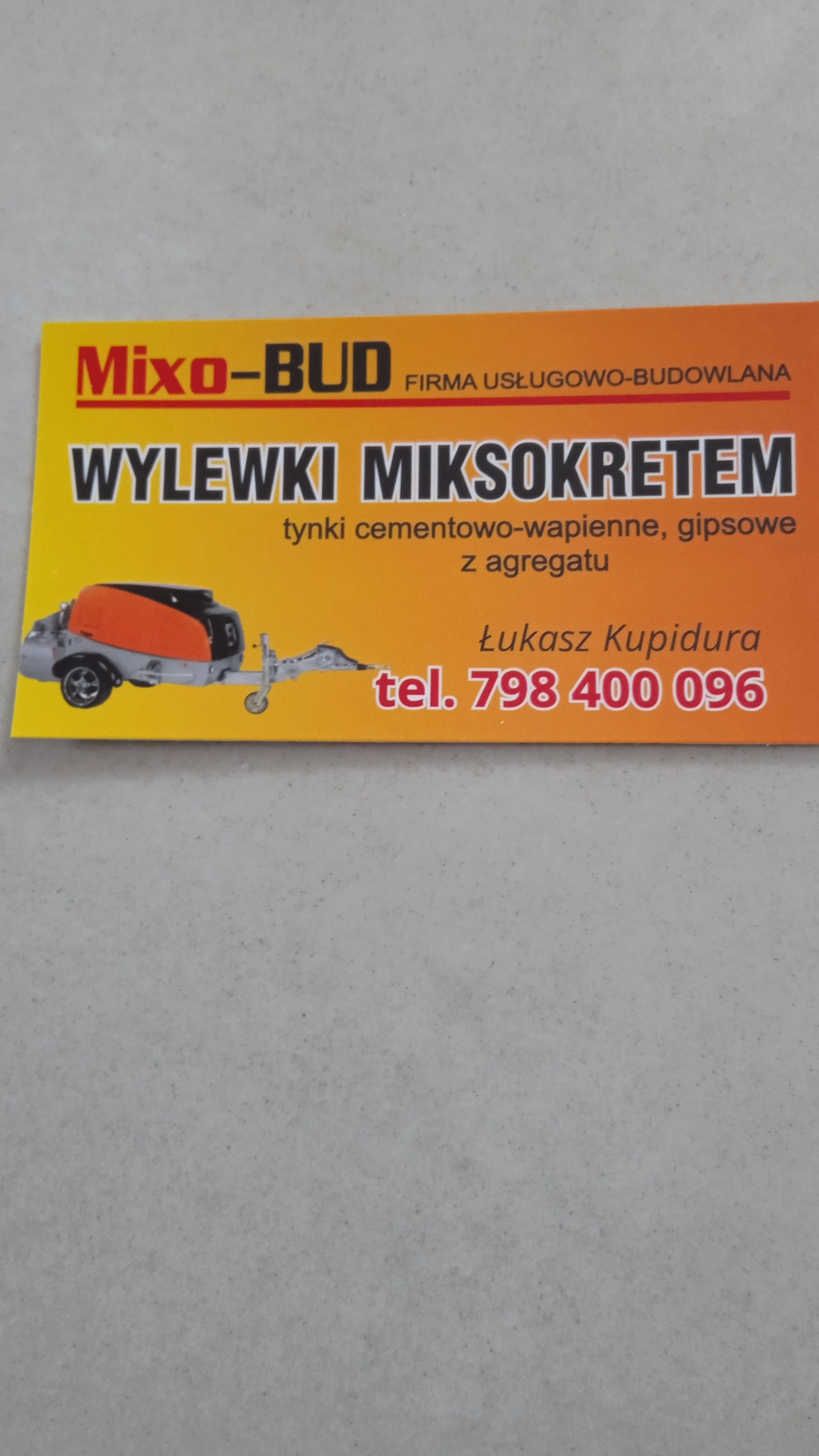 Wizytówka firmy Mixo-Bud oferującej wylewki miksokretem, tynki cementowo-wapienne i gipsowe z agregatu, z ilustracją agregatu do wylewek oraz numerem telefonu.