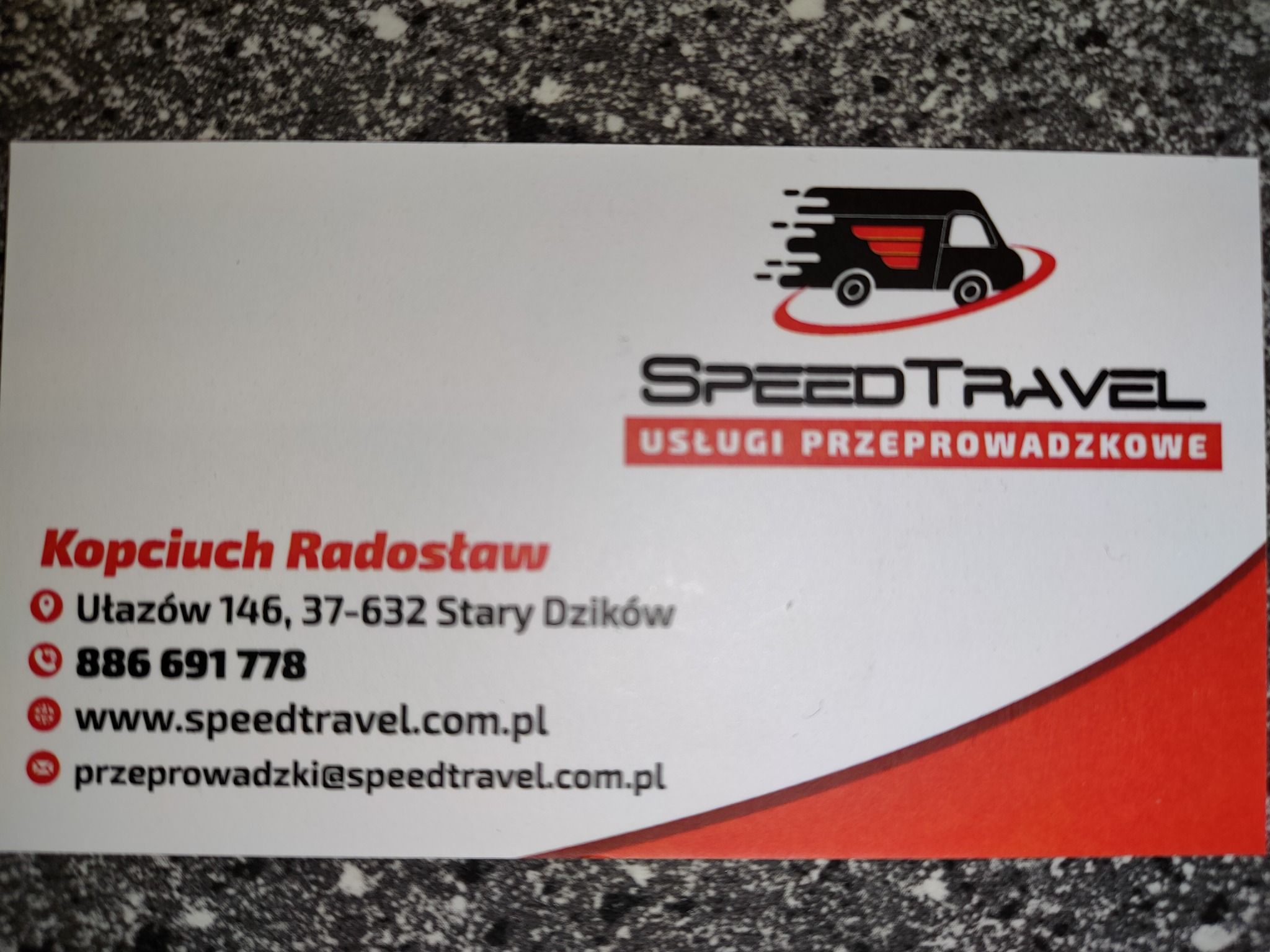 Wizytówka firmy SpeedTravel z logo przedstawiającym dynamiczny transportowy bus, oferującej usługi przeprowadzkowe, z adresem, numerem telefonu i adresem e-mail.