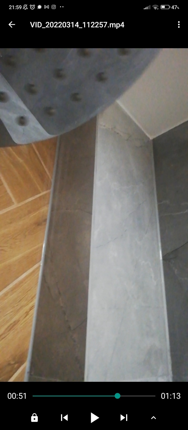 Fragment wykończonej łazienki w Jeleniej Górze, z widocznym prysznicem z deszczownicą, marmurowymi płytkami na ścianie i drewnopodobną podłogą.