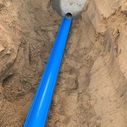 Time to Start (Danylo Chernytsia) - Niebieska rura osłonowa kabla elektrycznego ułożona w wykopie z piasku, widoczny fragment betonowej konstrukcji.