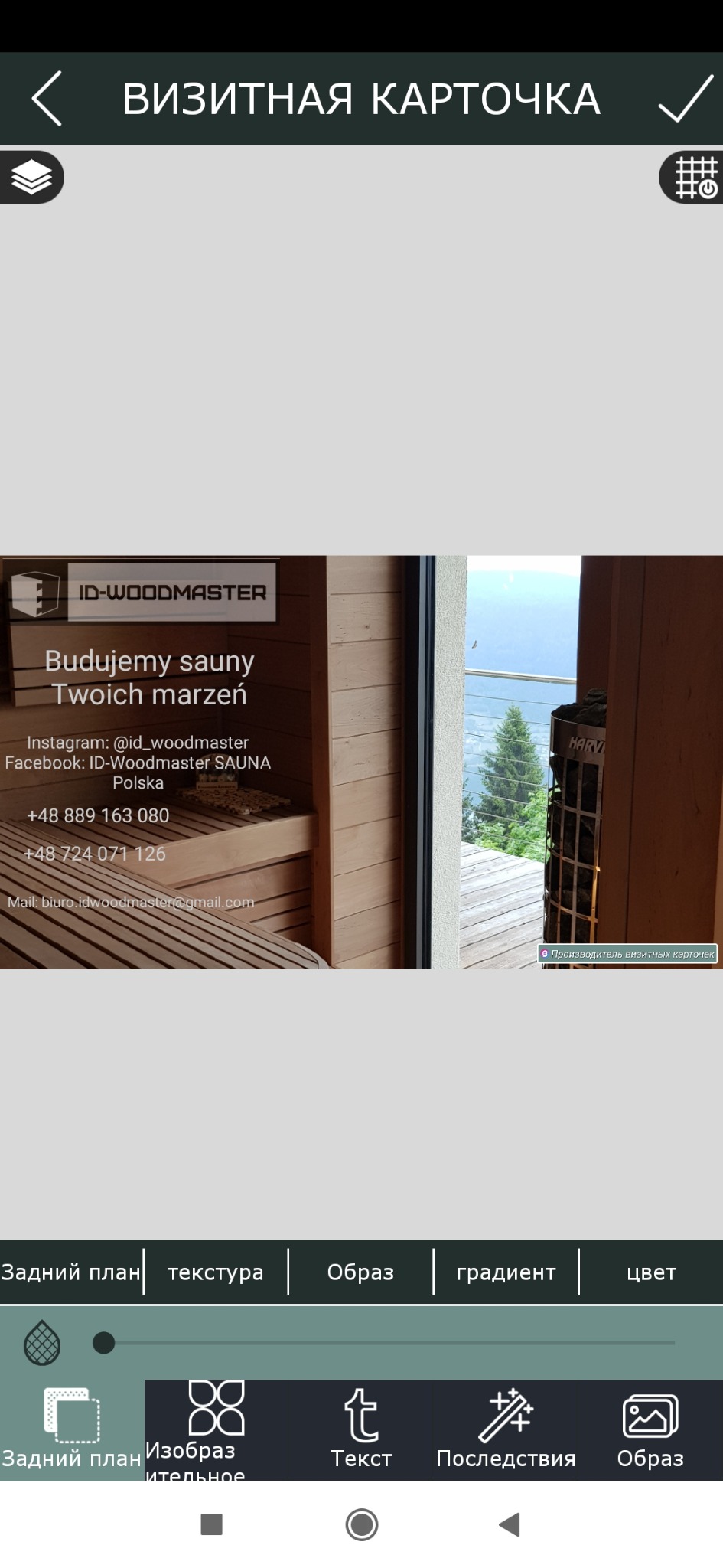 Ekran telefonu z otwartą aplikacją do projektowania wizytówek, prezentującą wizualizację drewnianej kabiny z piecem Harvia i widokiem na las, z logo ID-WOODMASTER i hasłem 'Budujemy sauny Twoich...