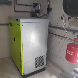 Nowoczesny piec na pellet Viteco Big Pellet Mini Compact w kotłowni, z widocznym zbiornikiem Kospel i instalacją hydrauliczną