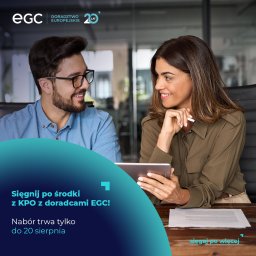 EGC Doradztwo Europejskie - Dwoje uśmiechniętych doradców omawia projekt na tablecie, dokumenty na stole, logo firmy EGC w tle.