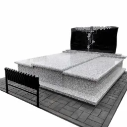 Granitowy nagrobek z czarną tablicą z motywem krzyża i kwiatów, uzupełniony o czarną metalową ławeczkę na kostce brukowej.