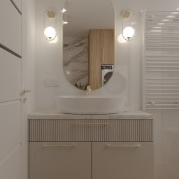 Avles Sebastian Selwa - Nowoczesna łazienka z owalnym lustrem, umywalką nablatową i szafką z ryflowanym frontem. W lustrze odbija się pralka w zabudowie. Minimalistyczne oświetlenie.