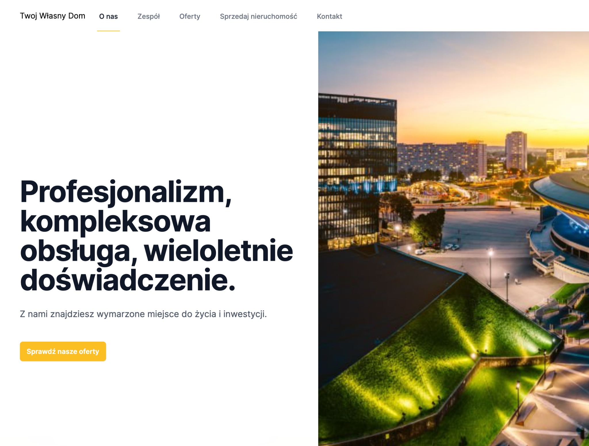 Widok na nowoczesne miasto nocą z wysokimi biurowcami i oświetlonymi ulicami, widziany z perspektywy dachu pokrytego zielenią.