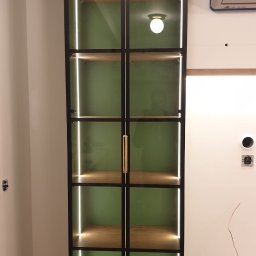 Pracownia SSQ - Wykonano witrynę z przeszklonymi frontami w ramce, korpusy płyta lakierowana mat, wewnątrz led