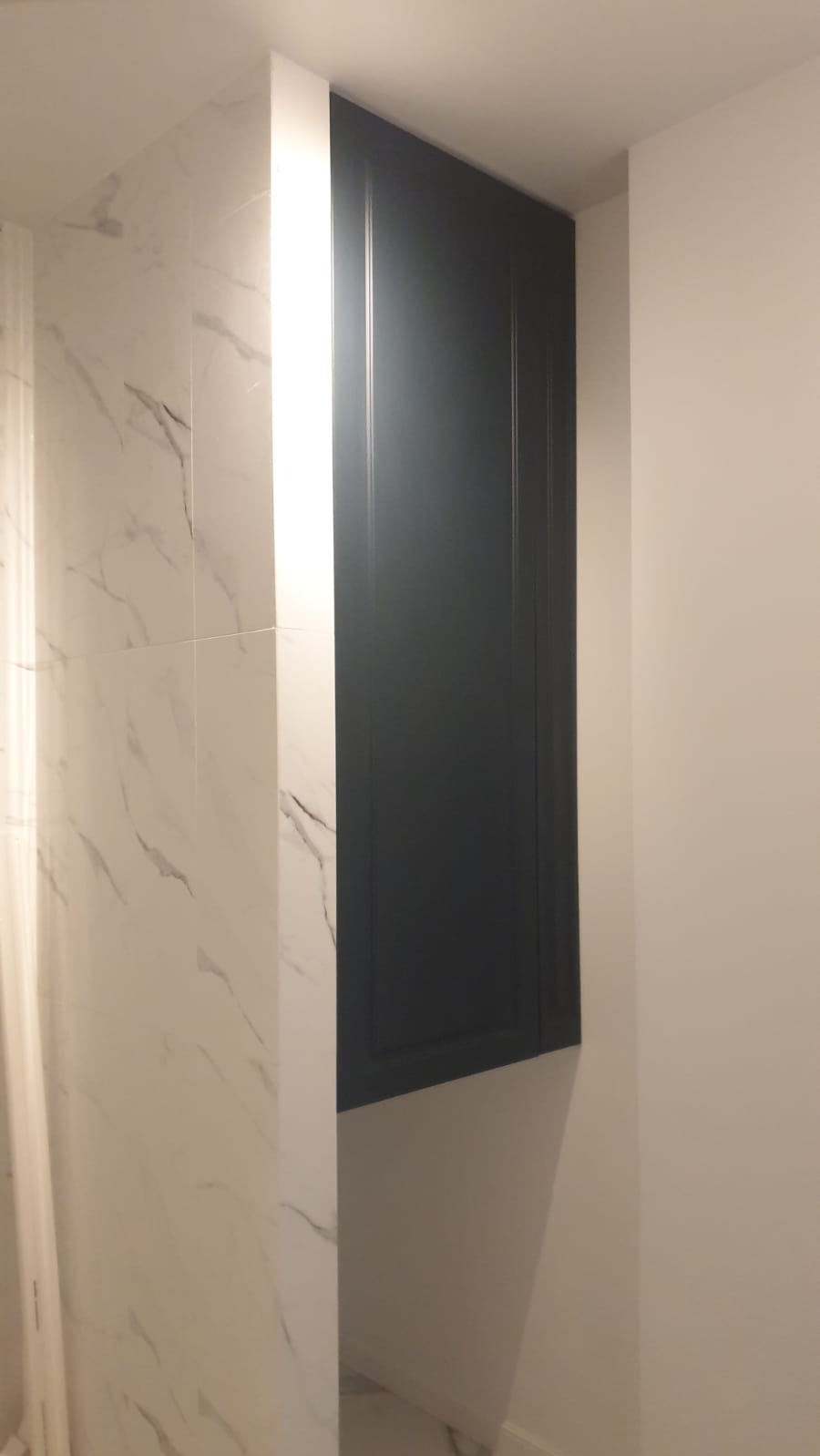 Wykonano szafkę wnękową w łazience, ponad pralką - front płyta lakierowana, frezowana mat.