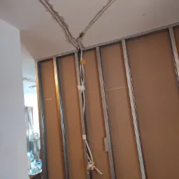 Instalacja elektryczna w bruzdach sufitowych przed montażem płyt kartonowo-gipsowych na metalowym stelażu.