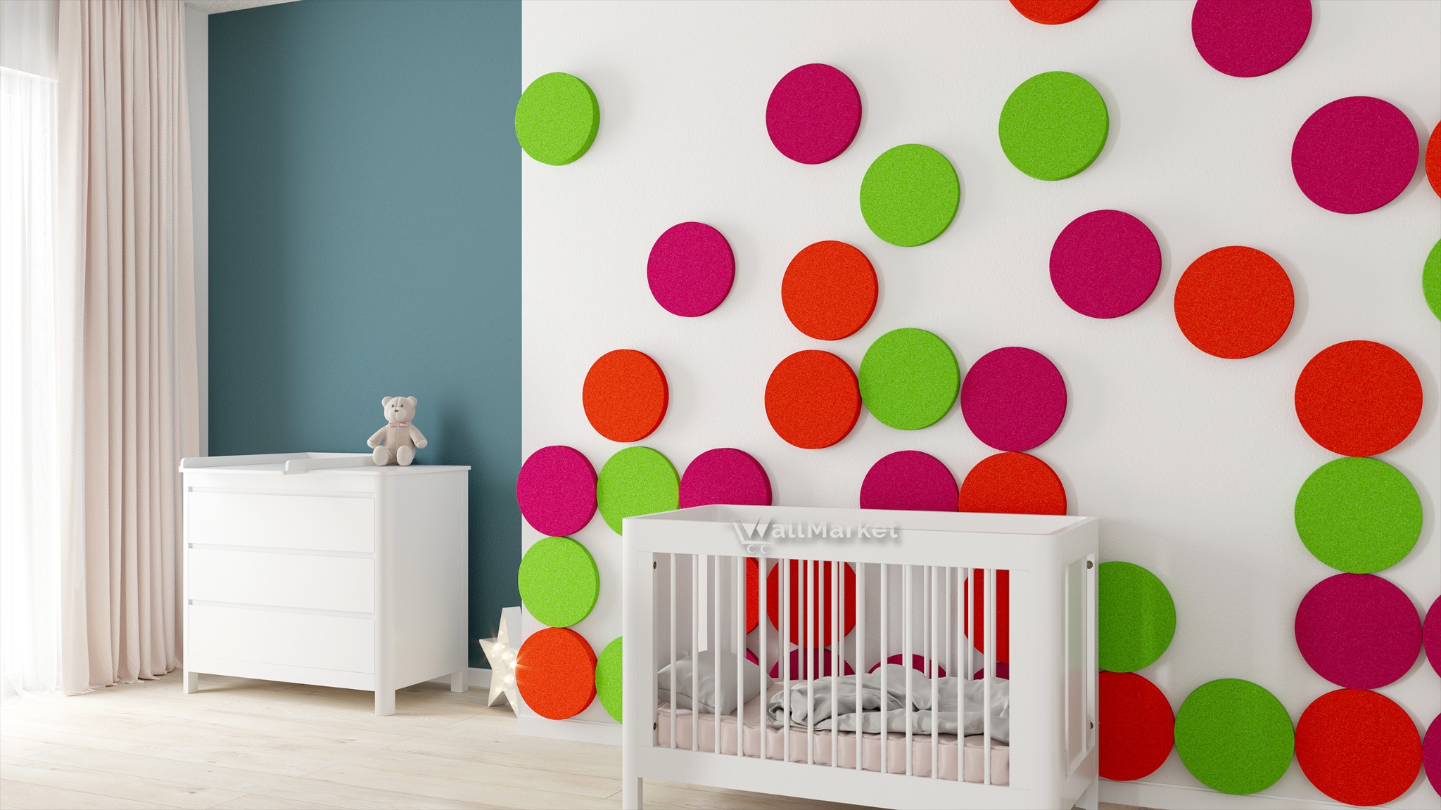Pokój dziecięcy z białym łóżeczkiem i komodą, ściana ozdobiona kolorowymi, okrągłymi panelami akustycznymi w odcieniach zieleni, różu i pomarańczy.