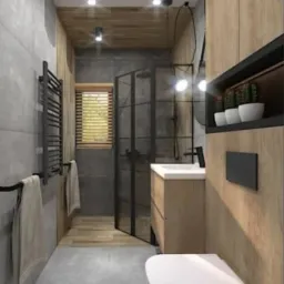 Nowoczesna łazienka z szarą płytką imitującą beton na ścianach, drewnianymi elementami zabudowy meblowej, kabiną prysznicową ze szklaną ścianą i czarnymi ramami, oraz wiszącą toaletą.