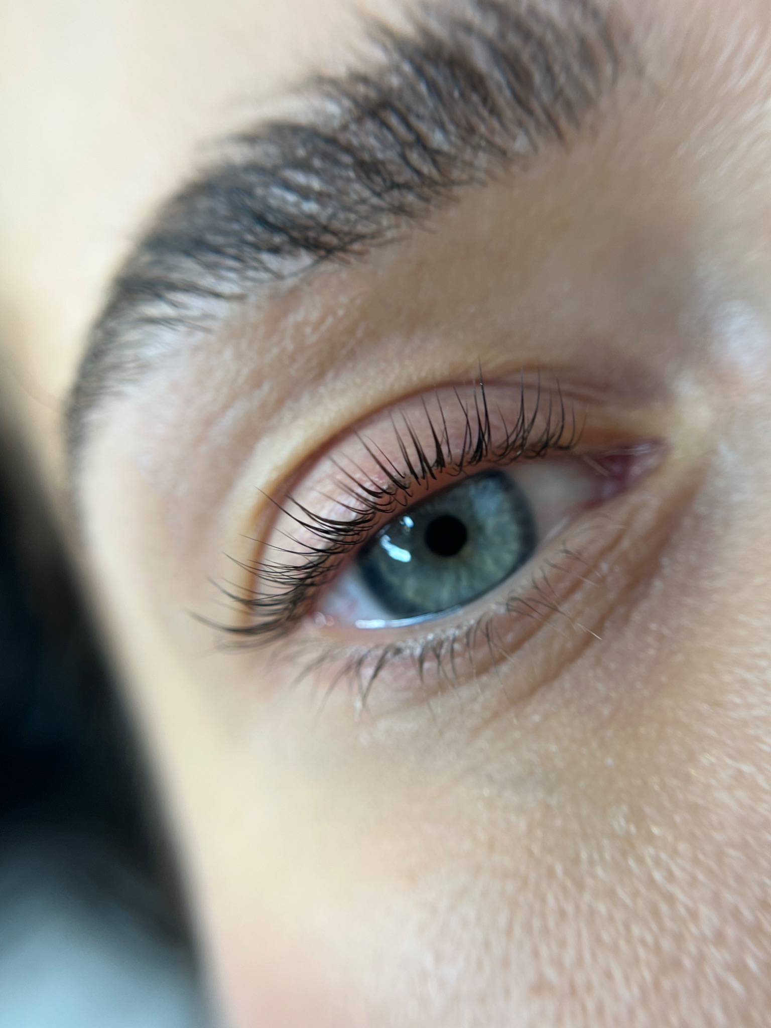 Zbliżenie na oko z delikatnie przedłużonymi rzęsami, podkreślając naturalny efekt i subtelne uniesienie.