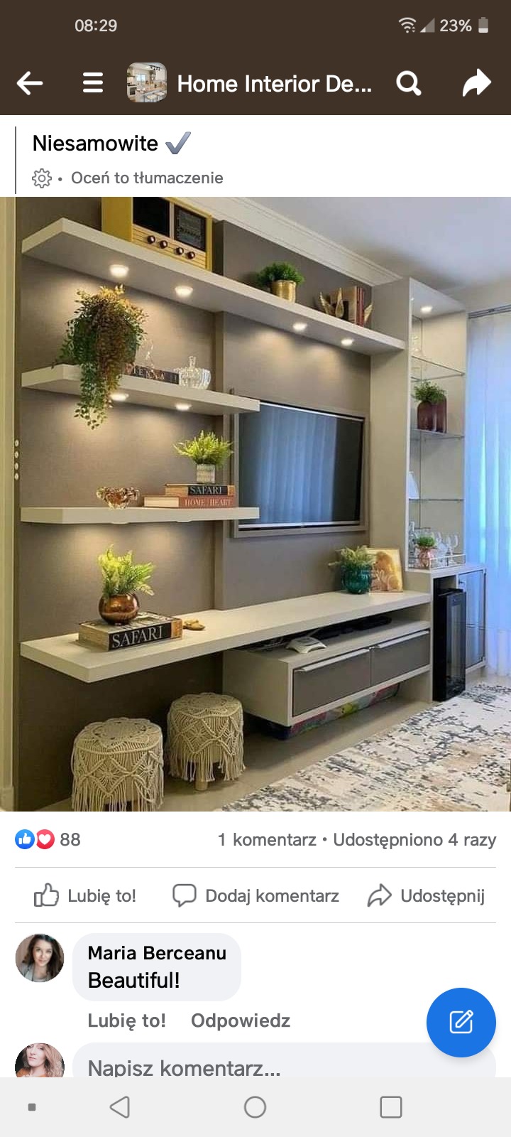 Elegancka aranżacja ściany telewizyjnej z półkami podświetlanymi punktowo, dekoracjami roślinnymi, książkami i dwoma pufami z makramy.