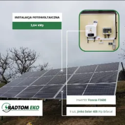Panel słoneczny Jinko Solar 405 Wp Bifacial z inwerterem Foxess F3600 i logo Radtom Eko, instalacja o mocy 3,64 kWp na tle pochmurnego nieba.