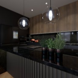 YUSH Studio Projektowania Wnętrz - Nowoczesna kuchnia z czarnym blatem i szklanymi lampami. Na blacie doniczki z ziołami. W tle drewniana ściana i czarne szafki. Minimalistyczny design.