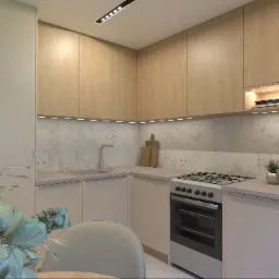 Jasna kuchnia z drewnianymi szafkami, marmurowym blatem i roślinami w doniczkach. Oświetlenie LED pod szafkami. Minimalistyczny design z drewnianymi deskami do krojenia.