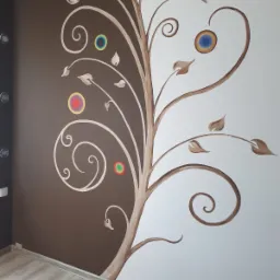Ręcznie malowana dekoracja ścienna przedstawiająca stylizowany drzewo z kolorowymi okręgami na ścianie podzielonej na brązową i białą część.