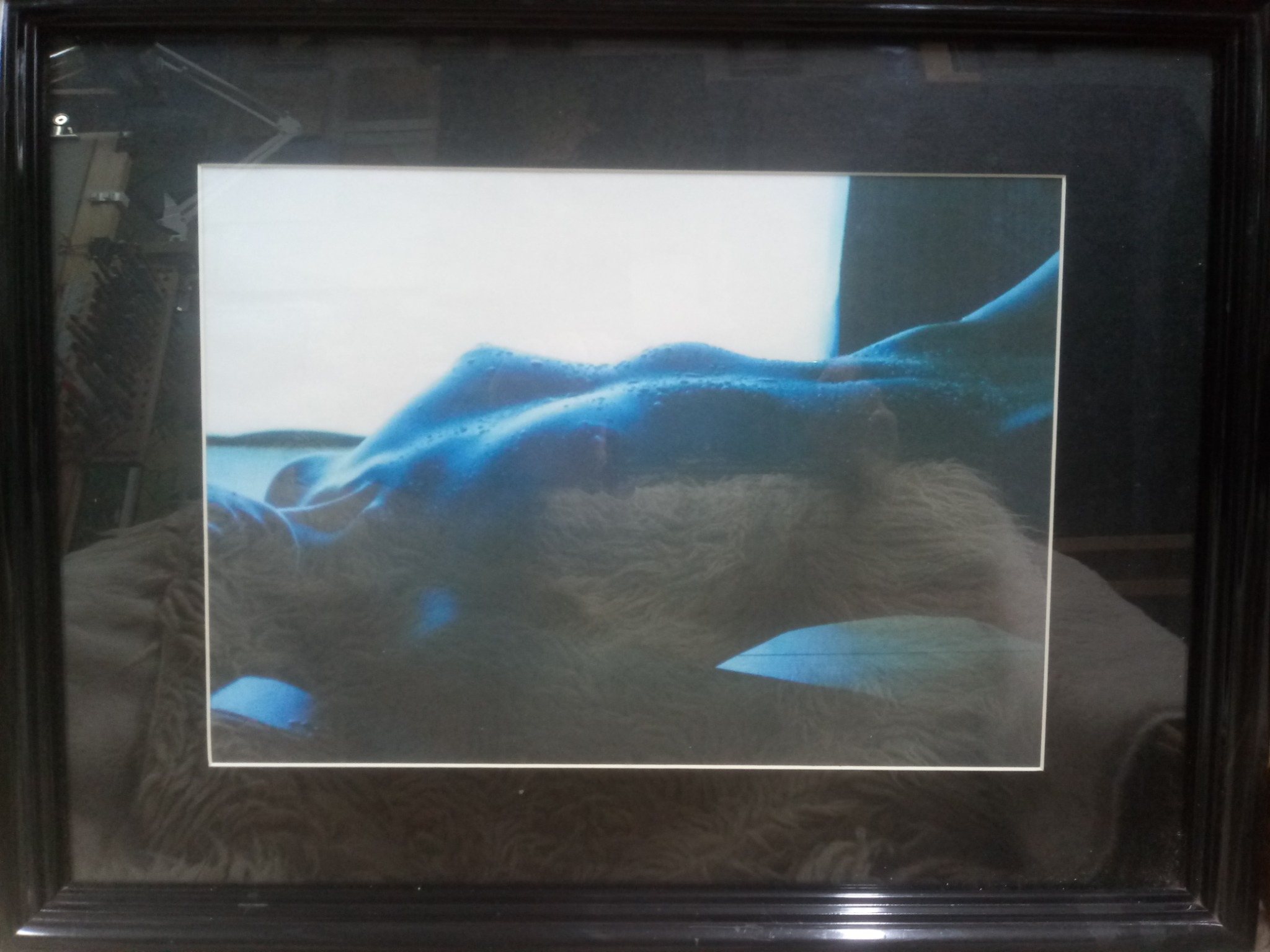 Oprawiony w czarną ramę obraz przedstawiający abstrakcyjny akt w odcieniach błękitu i bieli, z widocznymi kroplami na ciele modela i szorstką fakturą tła.