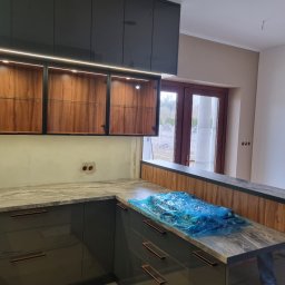 SONO MEBLE - Częściowo zrealizowana kuchnia na wymiar: grafitowe szafki dolne z blatem imitującym marmur, drewniane szafki wiszące z oświetleniem LED. Blat zabezpieczony folią.