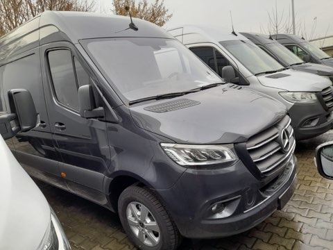 Rząd zaparkowanych szarych busów Mercedes Sprinter, widok z przodu, z anteną na dachu pierwszego pojazdu.