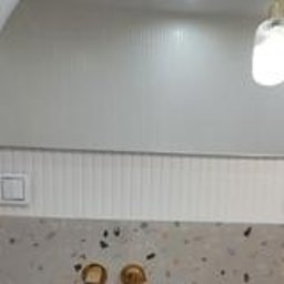 Wykończenia Andrzej Kobylański - Nowoczesna łazienka: lustro z zaokrąglonym blatem, złota armatura i subtelne oświetlenie. Minimalistyczny design z dbałością o detale.