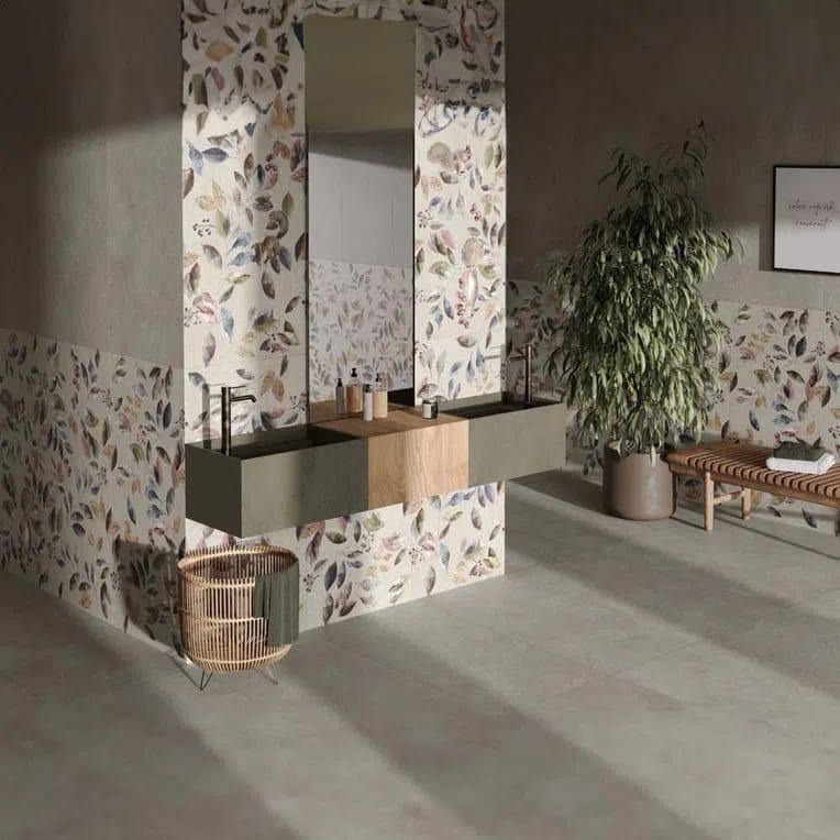 Nowoczesna łazienka z podwójną umywalką, lustrem i roślinnym motywem na płytkach. Minimalistyczny design, stonowana kolorystyka, drewniane akcenty i dekoracyjny kosz.