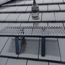 Nowy dach kryty ciemnoszarą dach&oacute;wką ceramiczną z zamontowanym stopniem kominiarskim i odpowietrznikiem.