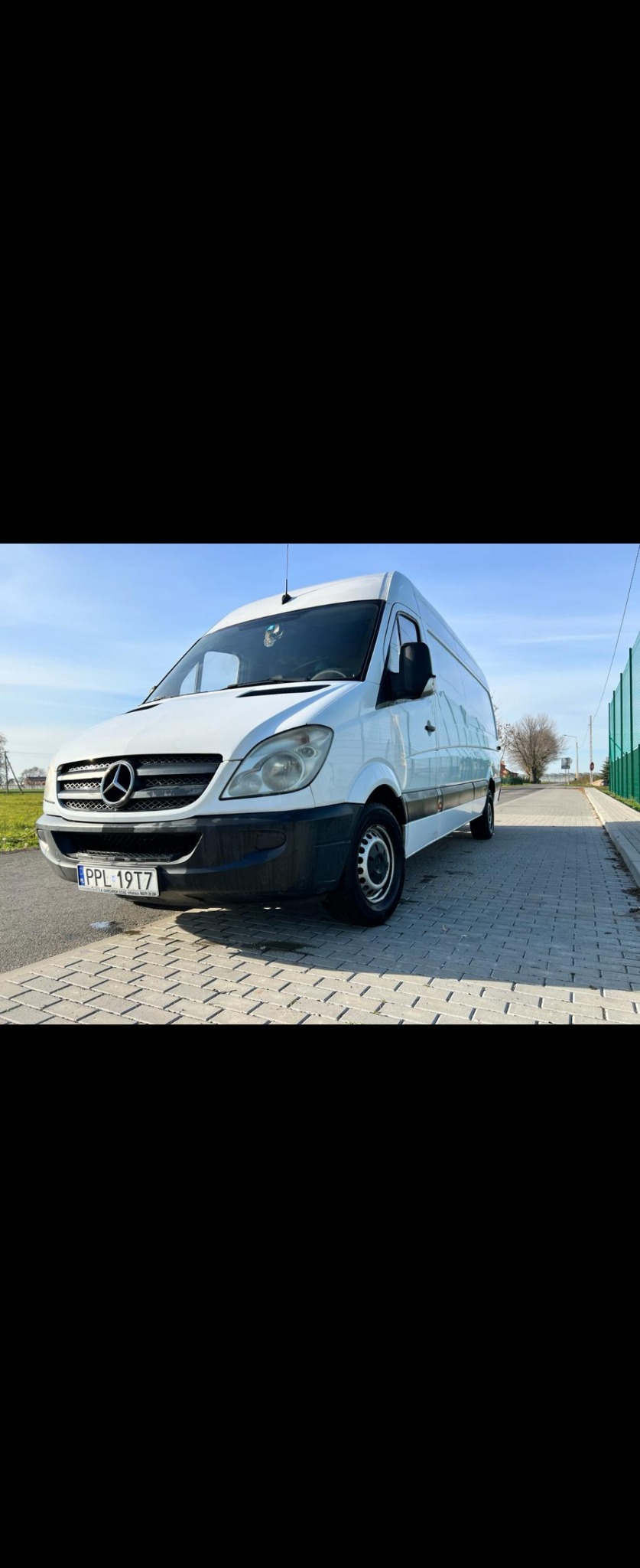 Biały samochód dostawczy Mercedes-Benz Sprinter z polską tablicą rejestracyjną PPL 19T7, stojący na kostce brukowej w słoneczny dzień.