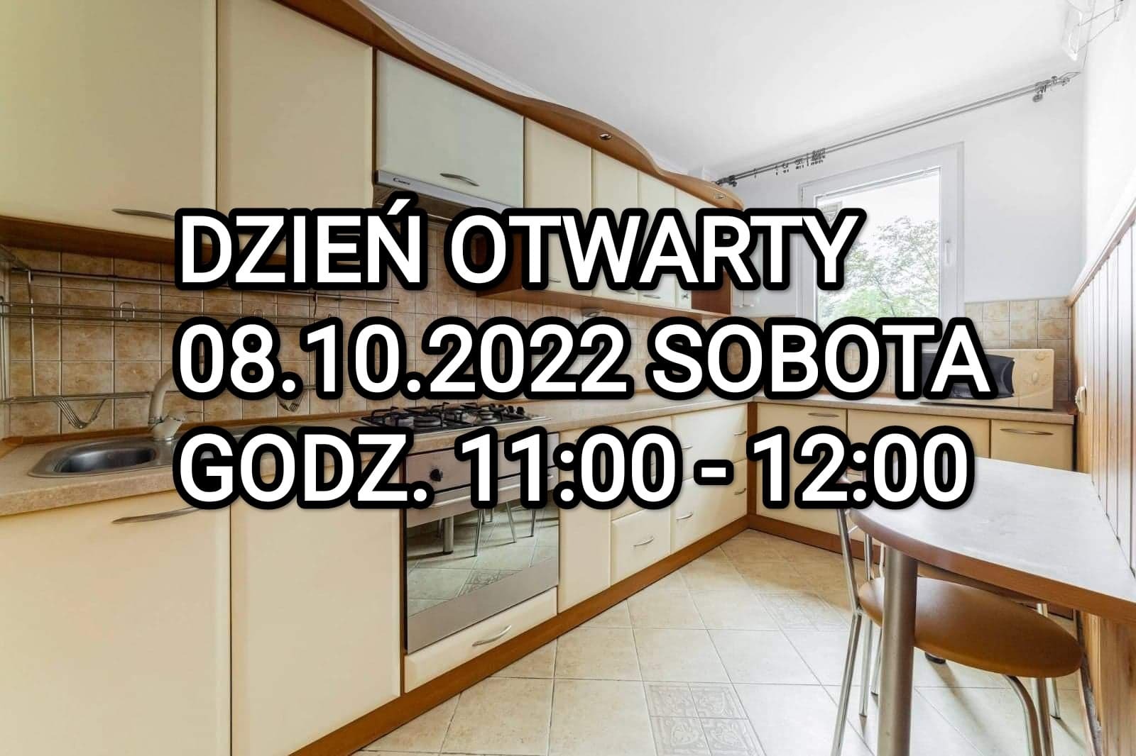 Kremowa kuchnia z beżowymi płytkami, na pierwszym planie duży napis 'Dzień Otwarty 08.10.2022 Sobota godz. 11:00-12:00', widok na okno i stół z krzesłem.