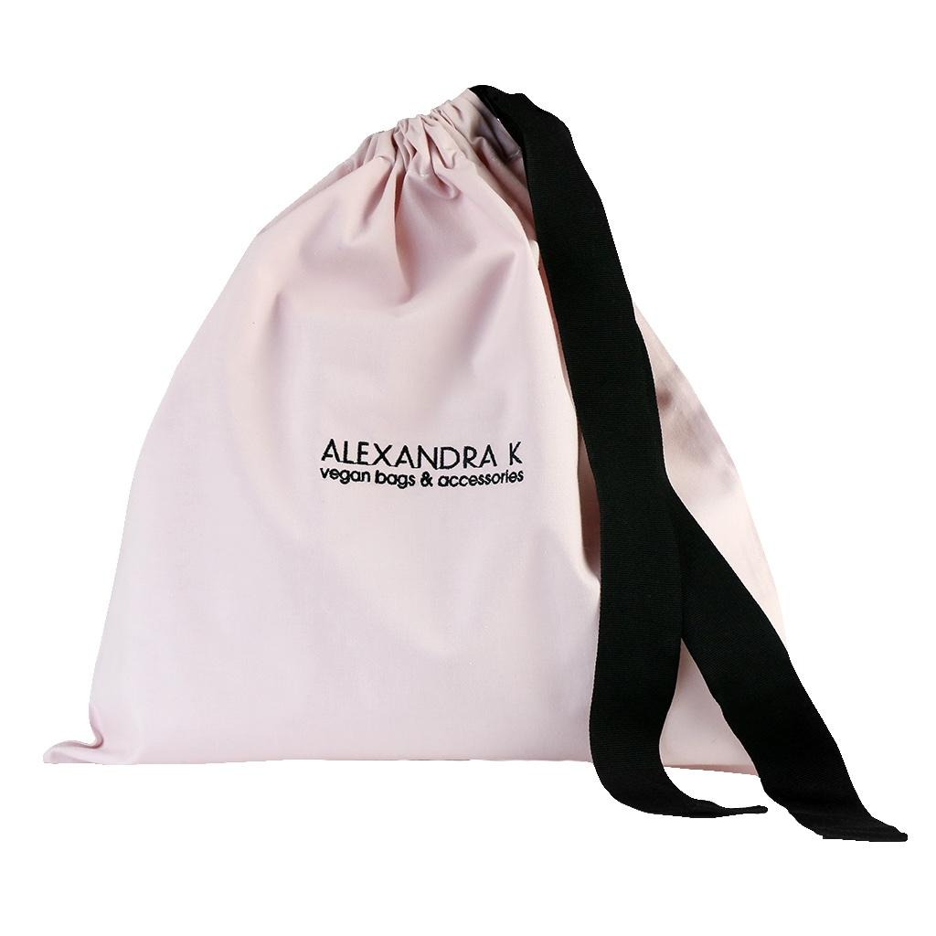 Jasnoróżowy worek ze sznurkiem i czarnymi uchwytami, z nadrukowanym logo 'ALEXANDRA K vegan bags & accessories'.