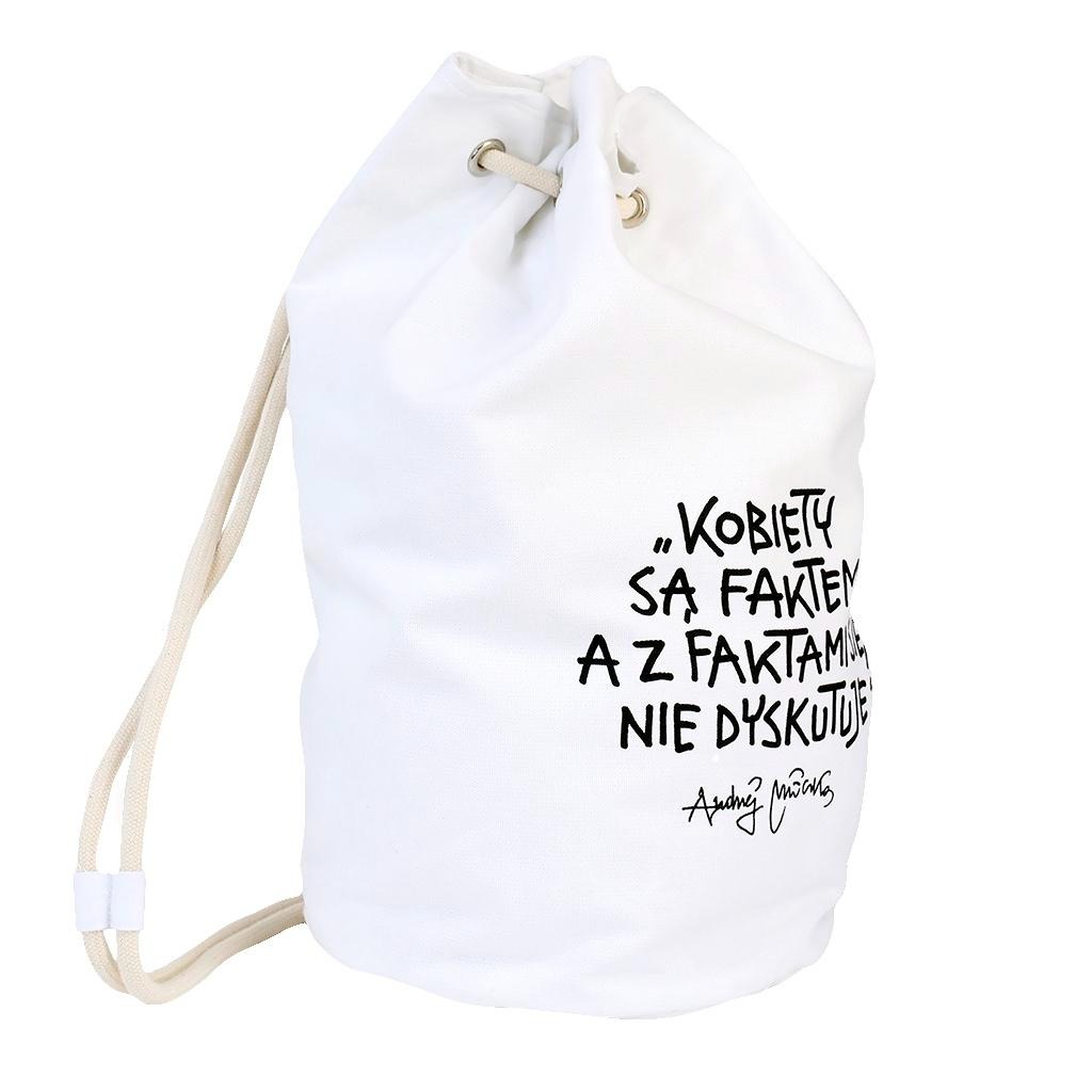 Biały, materiałowy worek ze sznurkiem, z czarnym nadrukiem cytatu 'Kobiety są faktem, a z faktami się nie dyskutuje' i podpisem Audrey Hepburn, na białym tle.