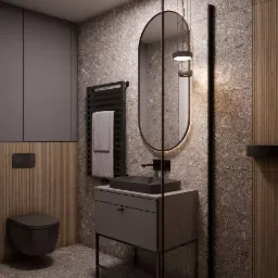 Nowoczesna łazienka w odcieniach szarości z owalnym lustrem z podświetleniem LED, minimalistyczną umywalką nablatową i grzejnikiem drabinkowym z ręcznikiem.