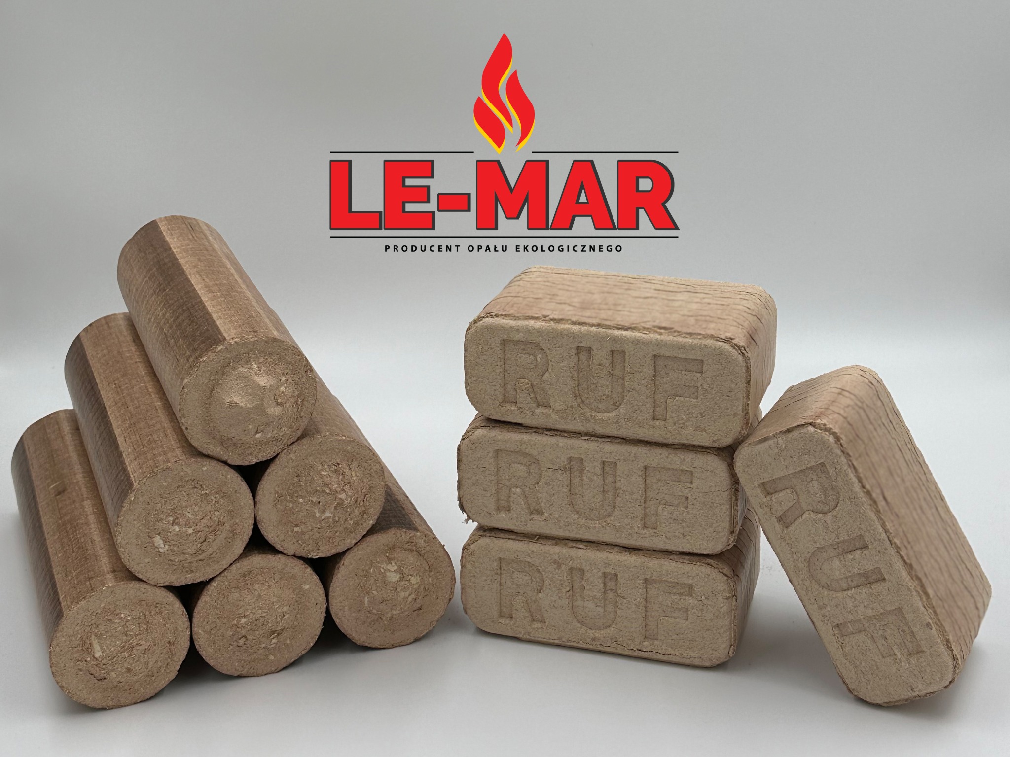 Ułożone obok siebie brykiety drzewne RUF w kształcie prostopadłościanów i walców, z widocznym logo producenta opału ekologicznego LE-MAR w tle.