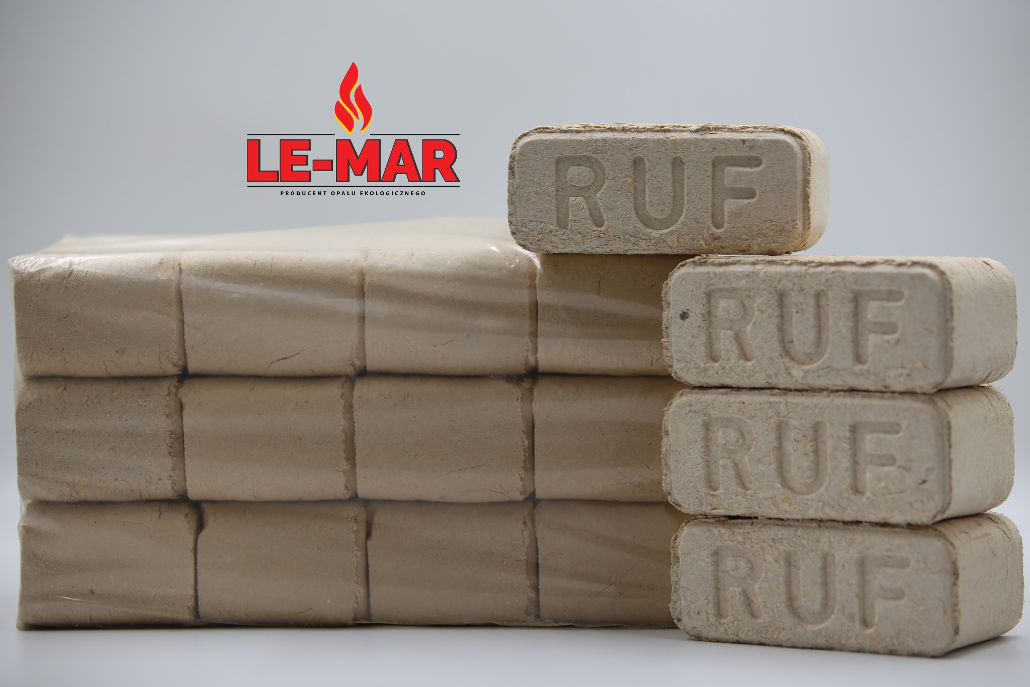 Ułożone kostki brykietu RUF, część zapakowana w folię, obok logo producenta 'LE-MAR'. Jasne tło, oświetlenie studyjne, neutralne kolory.