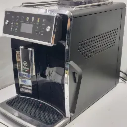 Automatyczny ekspres do kawy Saeco w czarnej obudowie z chromowanymi detalami, widoczny panel sterowania z ikonami różnych napojów, na białym tle.