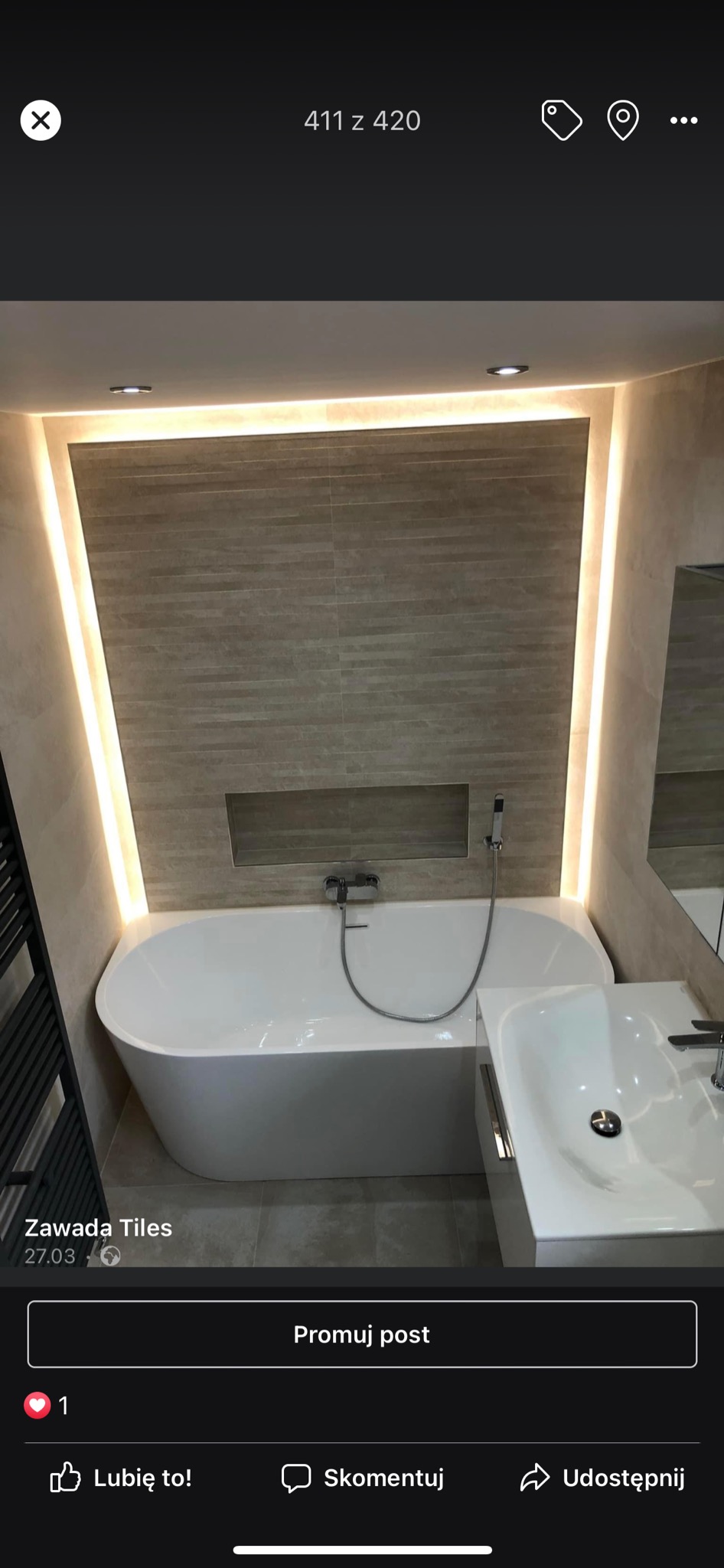 Nowoczesna łazienka z wanną wolnostojącą, umywalką na szafce i podświetleniem LED wokół płytek ściennych, tworzących wnękę nad wanną.