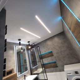 Gold Time Mykola Naboka - Nowoczesna łazienka z podświetleniem LED: liniowe lampy na suficie, niebieskie paski LED w niszach ściennych, lustro z podświetleniem i kabina prysznicowa ze szkła hartowanego.