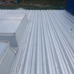 Srebrna blacha trapezowa na dachu przemysłowym z dwoma świetlikami dachowymi, widok z góry.