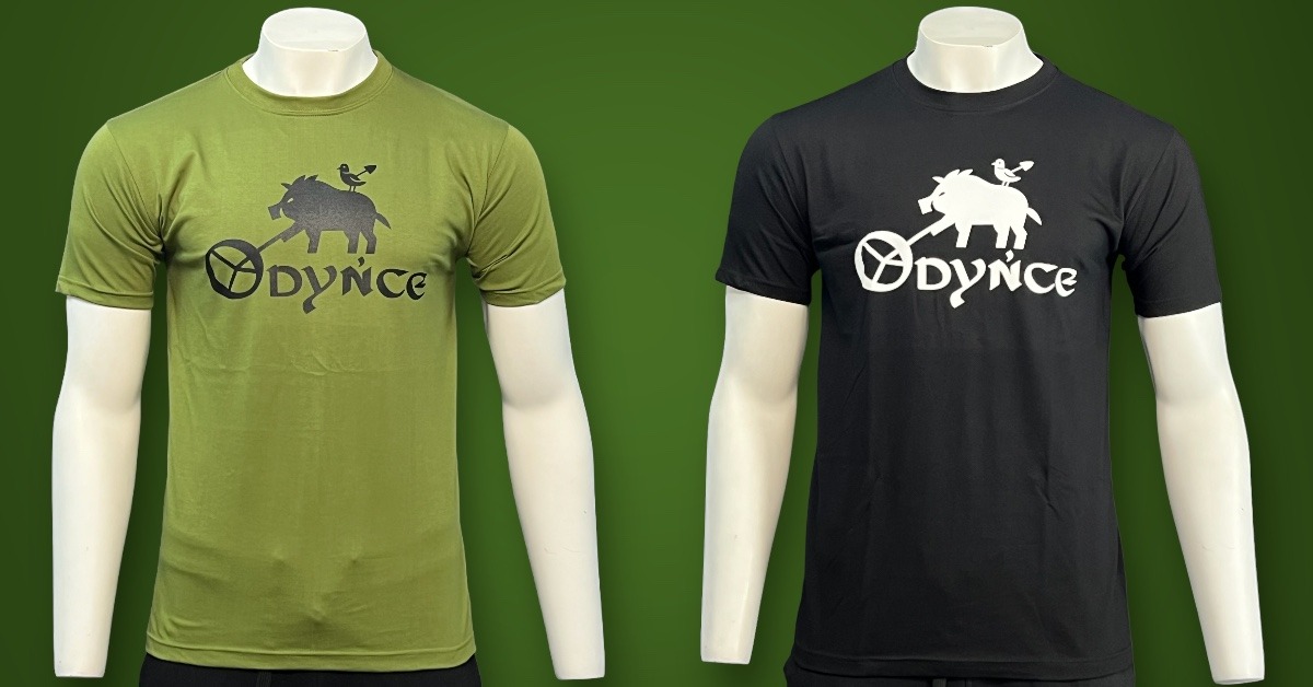 Dwa manekiny prezentują koszulki: oliwkową z czarnym nadrukiem dzika z ptakiem i napisem 'Odynce' oraz czarną z białym nadrukiem tego samego motywu.