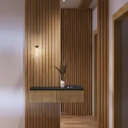 Nowoczesny hol wejściowy z drewnianą boazerią pionową, wiszącą szafką z ciemnym blatem, szklaną lampą kulą i dekoracją z suszonych traw w ceramicznym wazonie.