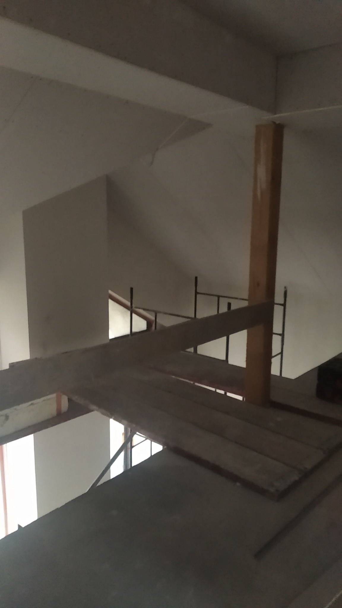 Szkielet konstrukcji poddasza z widocznym rusztowaniem i drewnianymi belkami podtrzymującymi, przygotowany pod ocieplenie.