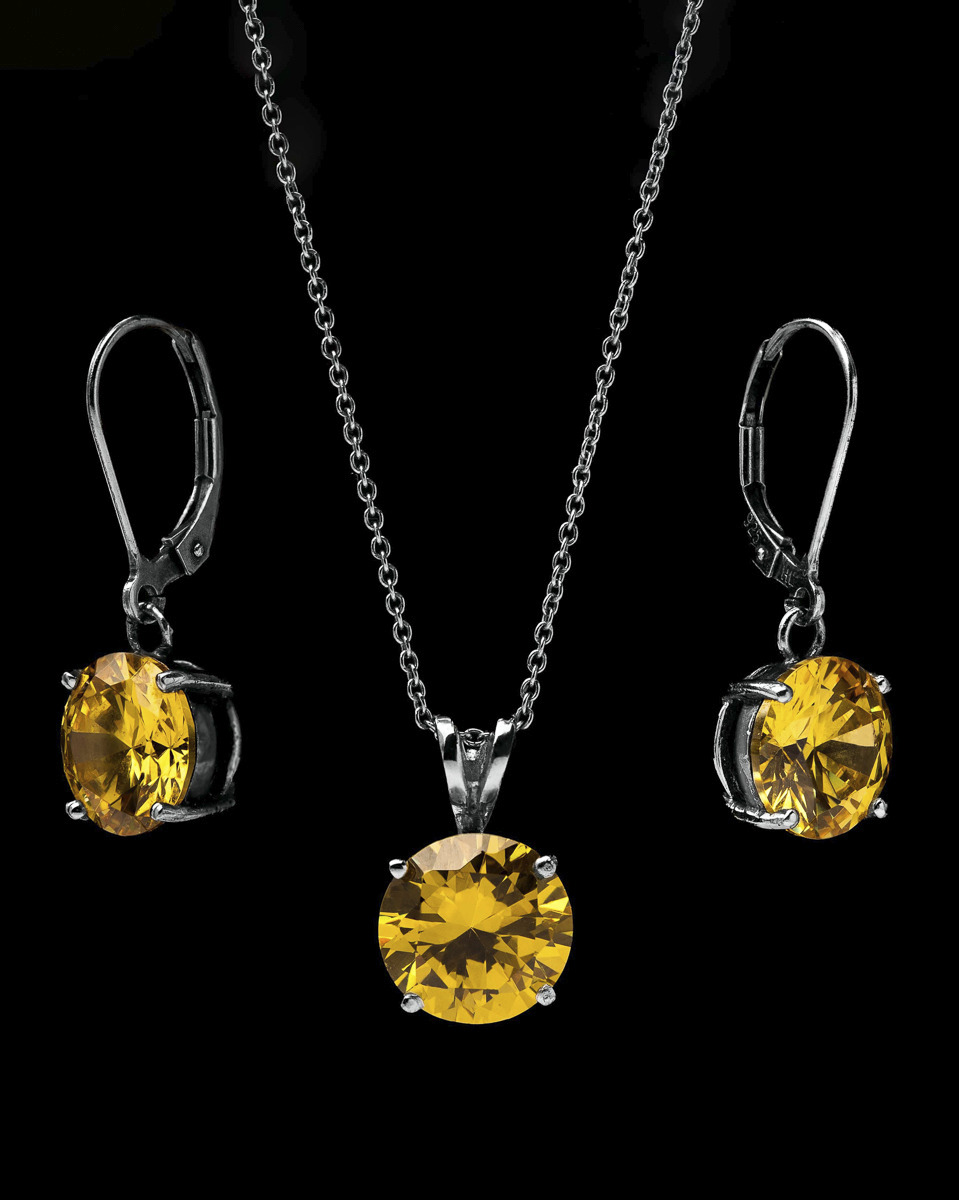 Srebrny komplet biżuterii: kolczyki wiszące i naszyjnik z okrągłymi, żółtymi kamieniami na czarnym tle.