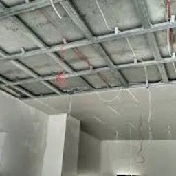 Stelaż metalowy podwieszony do sufitu z widocznymi przewodami elektrycznymi, przygotowany do montażu okładziny.