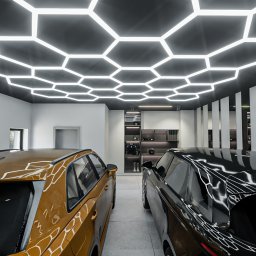 Adam Jasek Design Studio - Nowoczesny salon samochodowy z dwoma samochodami: złotym i czarnym, podświetlony heksagonalnym oświetleniem sufitowym i minimalistycznymi białymi panelami ściennymi.