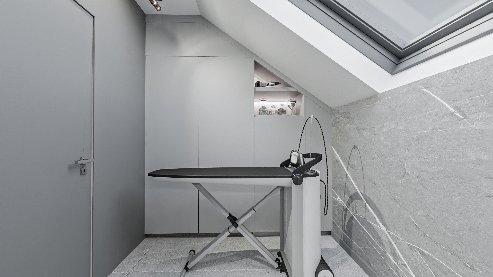 Szare wnętrze ze skośnym sufitem, marmurową ścianą i deską do prasowania z generatorem pary; w tle zabudowa meblowa z otwartą półką.