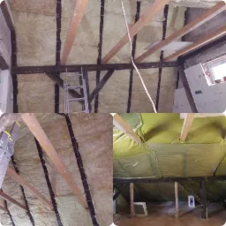 Poddasze z widoczną izolacją z wełny mineralnej pomiędzy drewnianymi krokwiami, częściowo pokryte folią paroizolacyjną, z aluminiową drabiną opartą o jedną z krokwi.