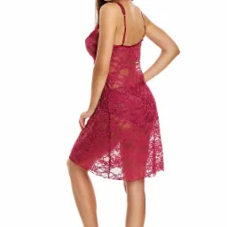 Kobieta w koronkowej, burgundowej koszuli nocnej na ramiączkach, odwr&oacute;cona tyłem, z uśmiechem spogląda przez ramię na białym tle.