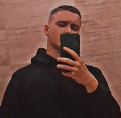 Mężczyzna w czarnej bluzie z kapturem robi selfie w łazience. Zdjęcie wykonane telefonem komórkowym. Firma z Górna.