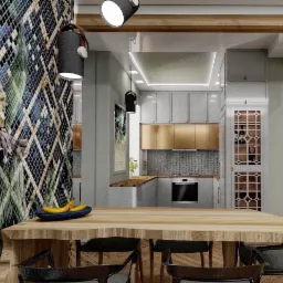 Nowoczesna kuchnia z wyspą i drewnianym blatem, na którym leżą banany w niebieskiej misce. Ściana ozdobiona mozaiką w odcieniach zieleni i niebieskiego. Oświetlenie punktowe nad wyspą.